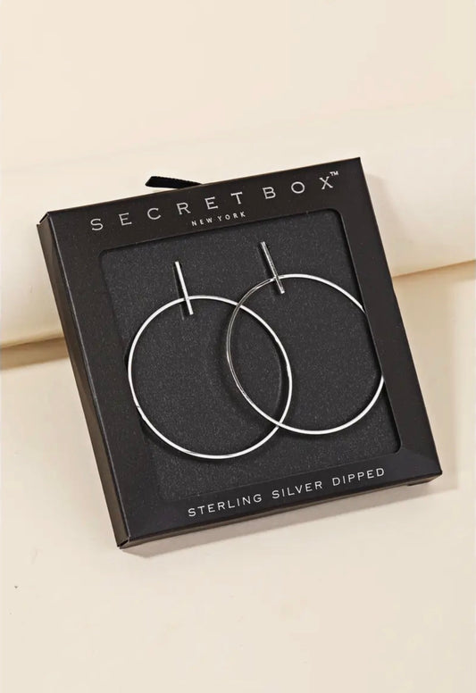 Sterling silver hoop earrings in a black square box by Secretbox New York, with 'STERLING SILVER DIPPED' printed on the front.